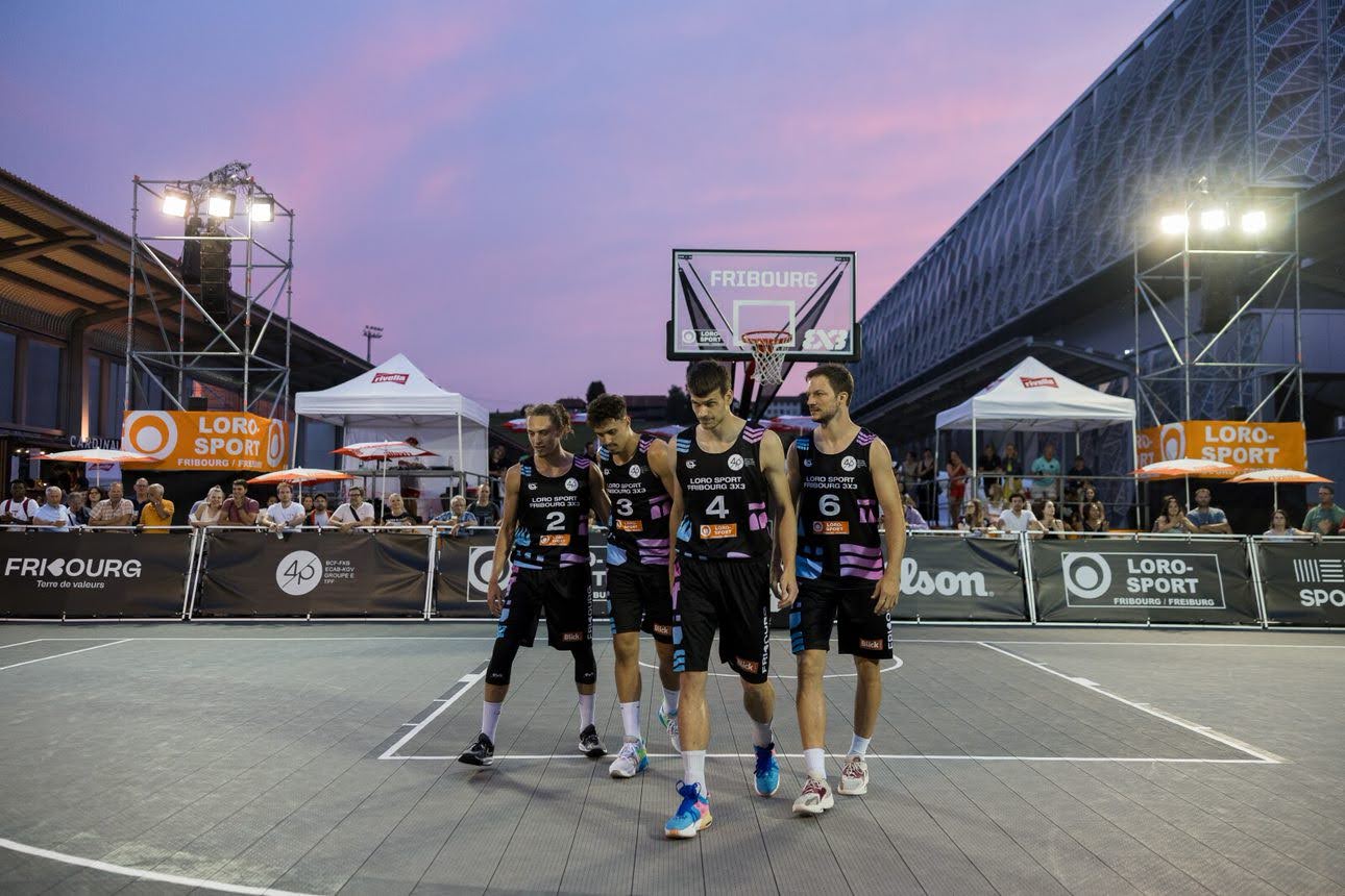 Joueurs de basket sur un terrain devant une foule