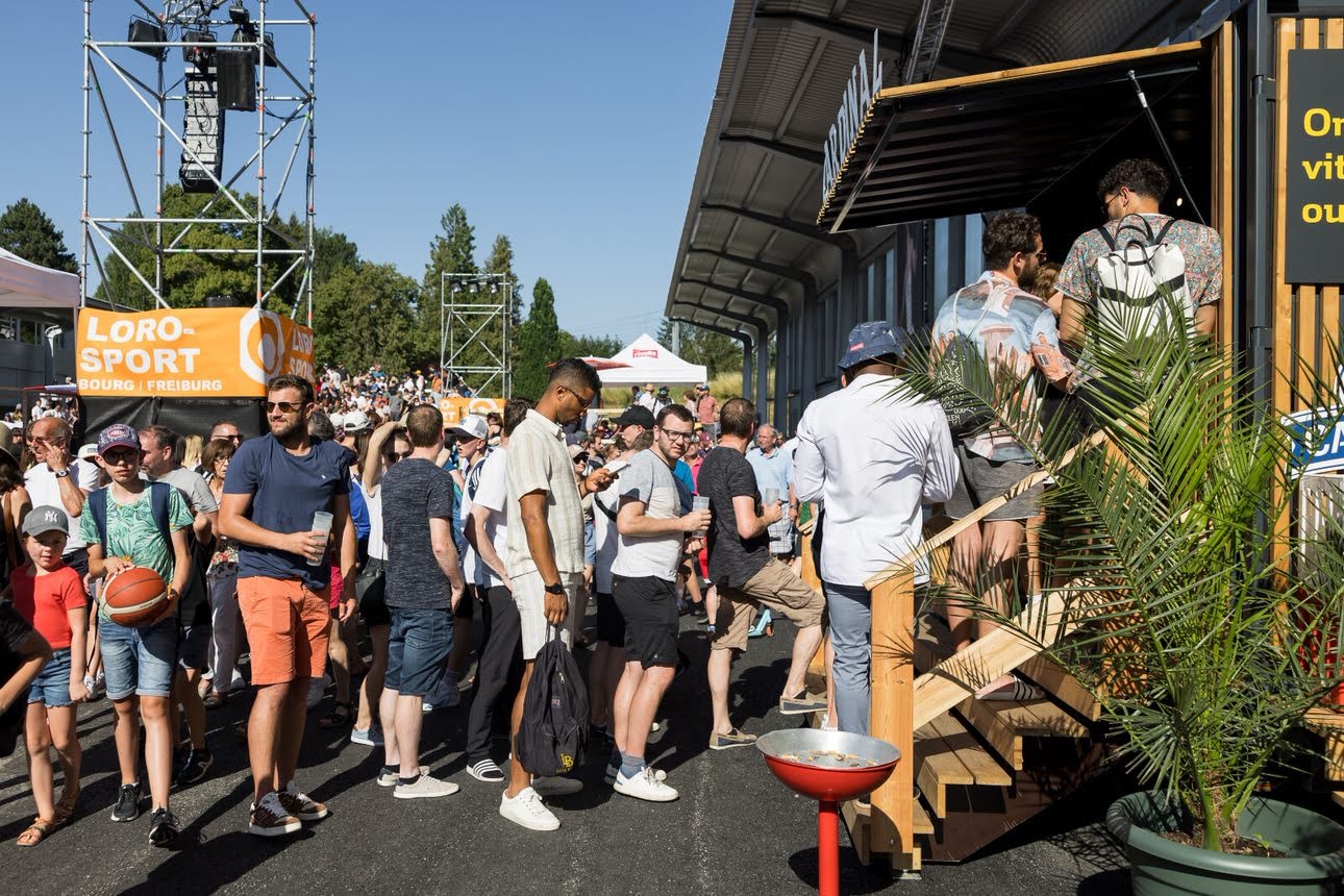 Une foule de personnes rassemblées lors d'un événement en plein air, profitant des activités.